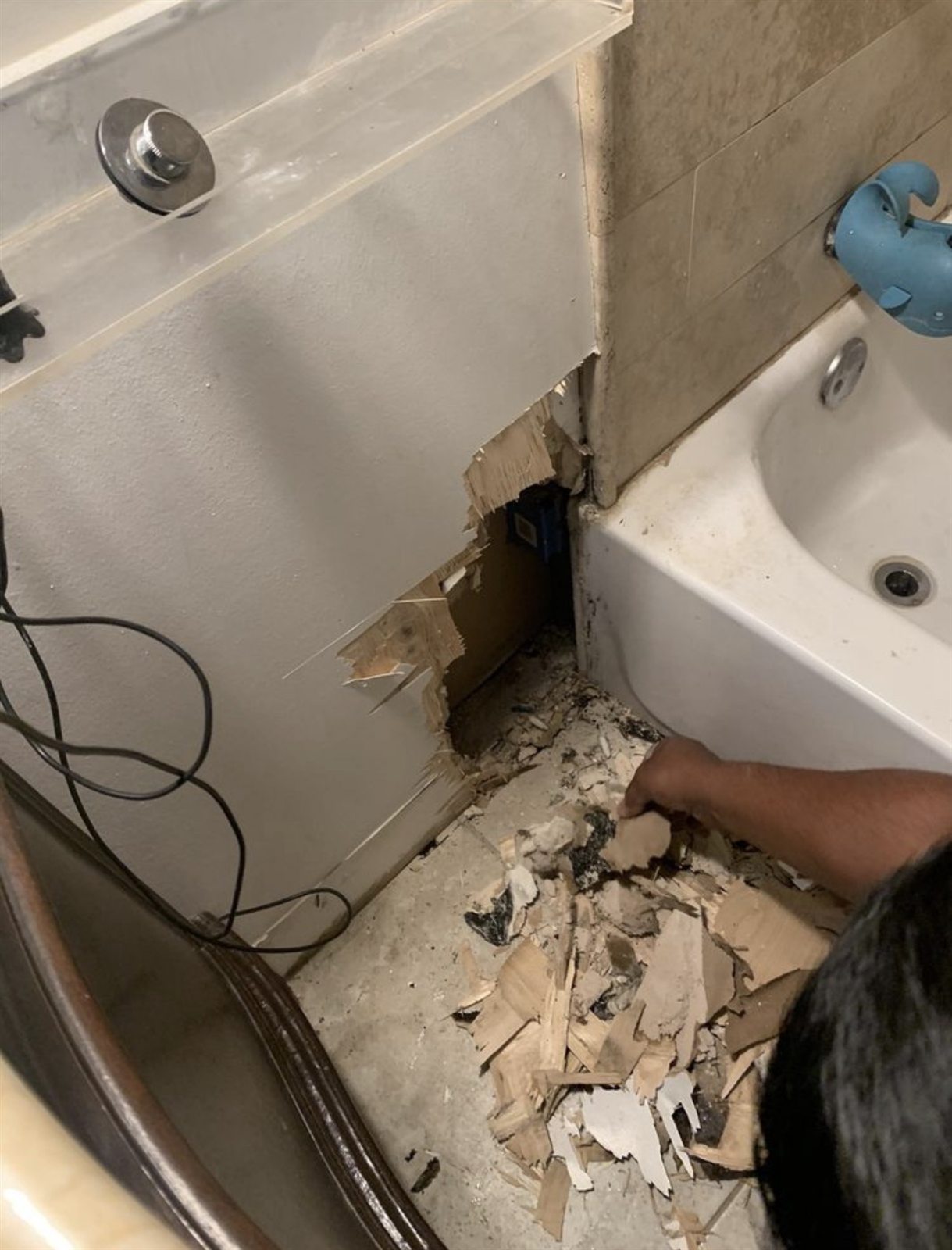 Bathroom wall with water-damaged drywall cut out, before Fairview Paint repair